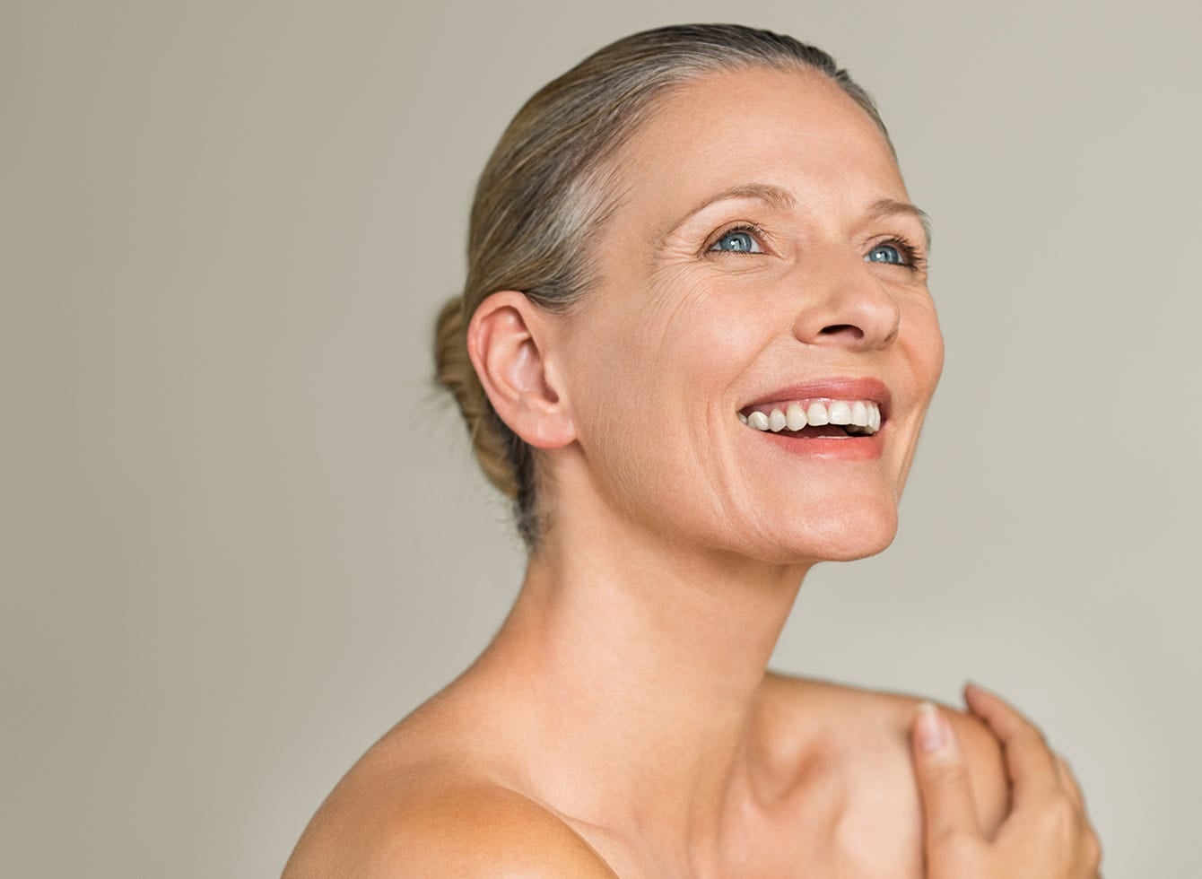 A woman joyfully smiles, expressing happiness and positivity with her collagen intake