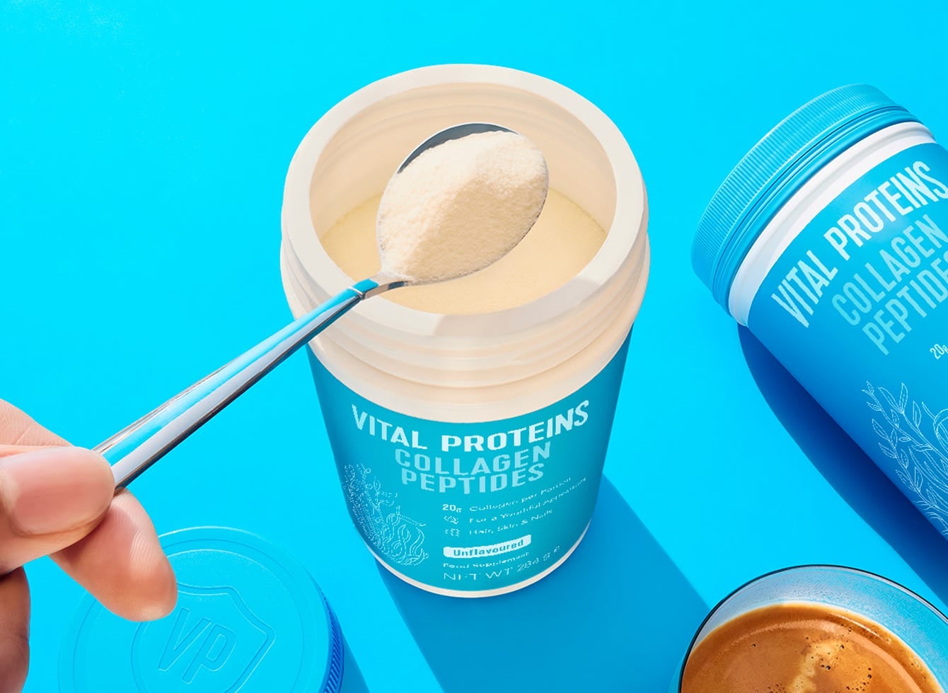 Collagen coffee beeing prepared, mixing coffee and collagen powder in a clear glass cup.